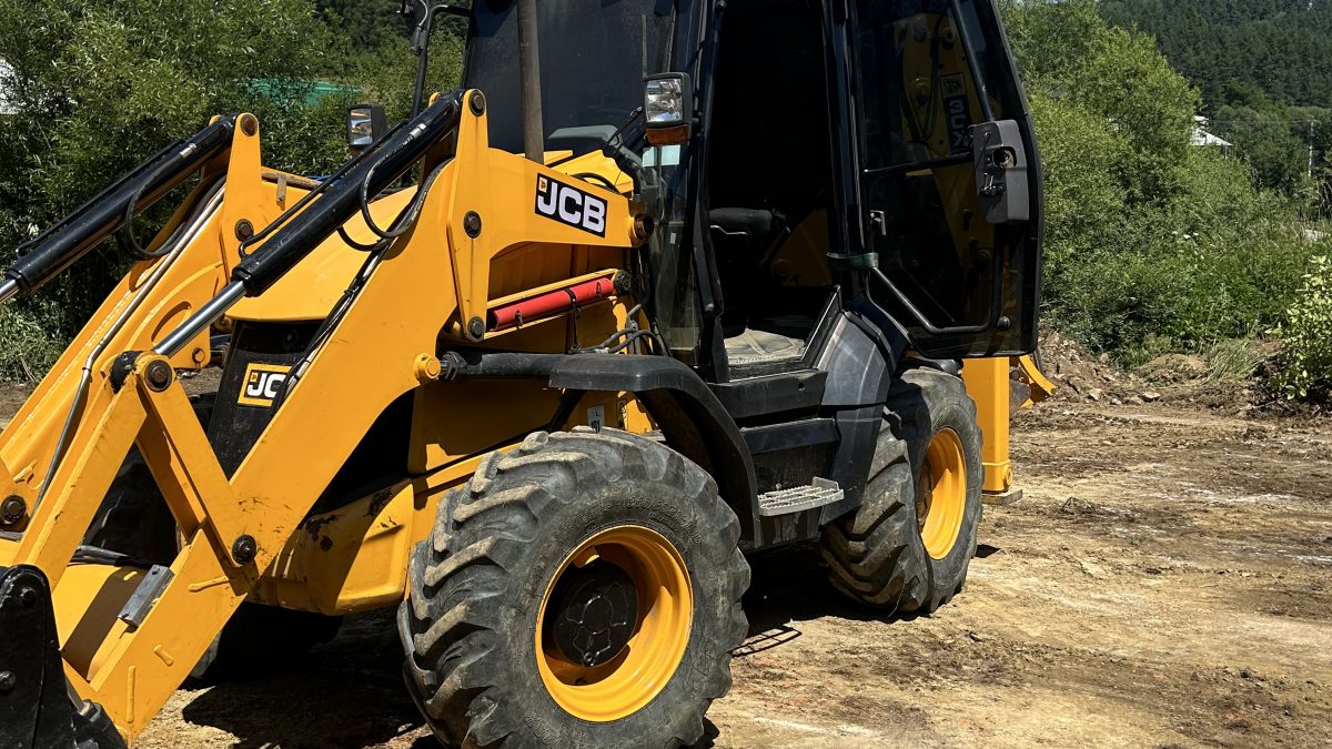 Traktorbager JCB 3CX Compact pripravený na zemné práce a úpravy terénu na stavebnom pozemku. Vhodný pre výkopové práce a manipuláciu s pôdou, tento kompaktný stroj je ideálny pre stavebné projekty spoločnosti po-bagrujem.sk.